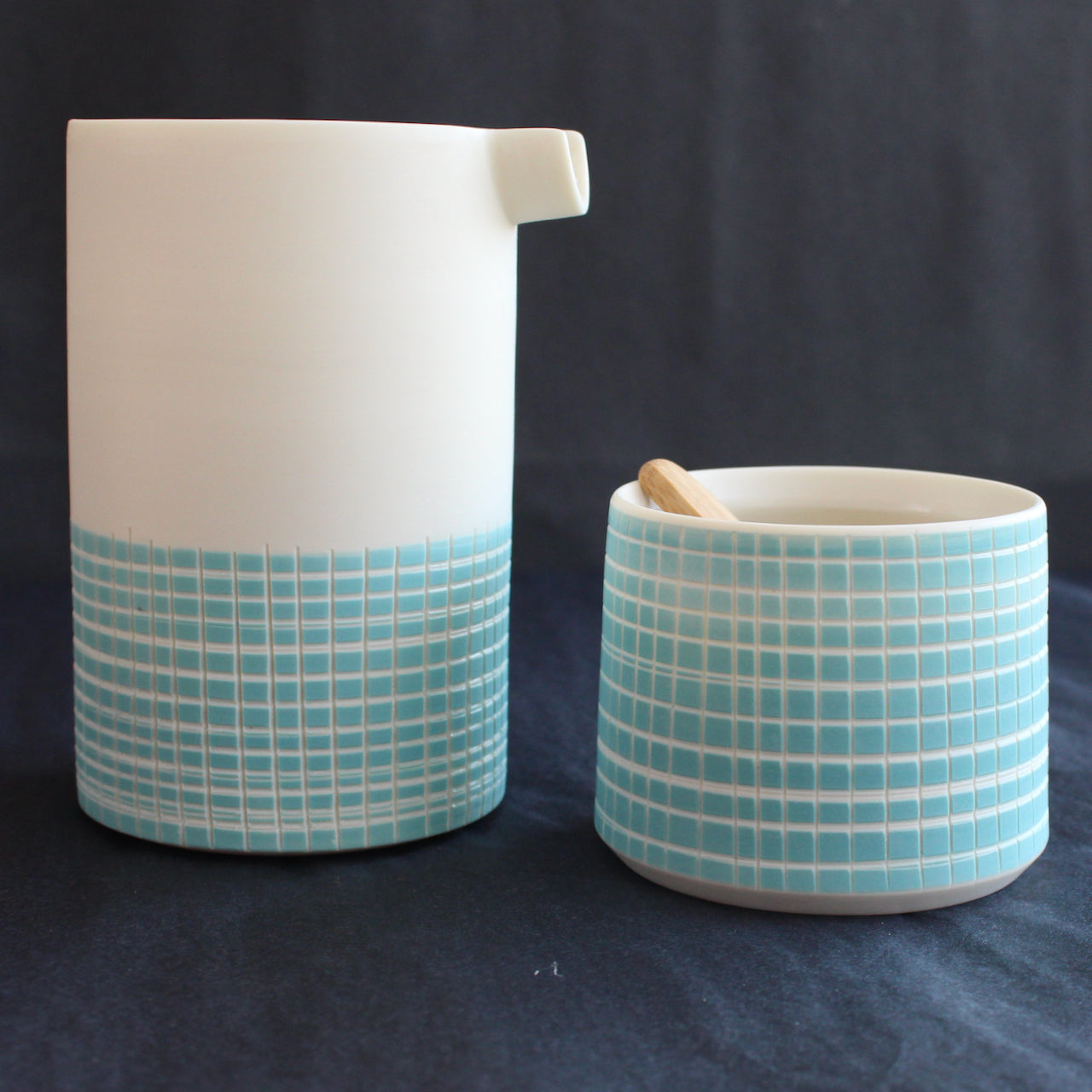 porcelain pourer and condiment bowl by Kathryn Sherriff of By the Line Pottery they are made of porcelain with a blue cross hatch design which covers the whole bowl and the bottom half of the pourer.