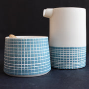 a porcelain pourer and condiment bowl by Kathryn Sherriff of By the Line Pottery decorated with a blue cross hatch glaze 