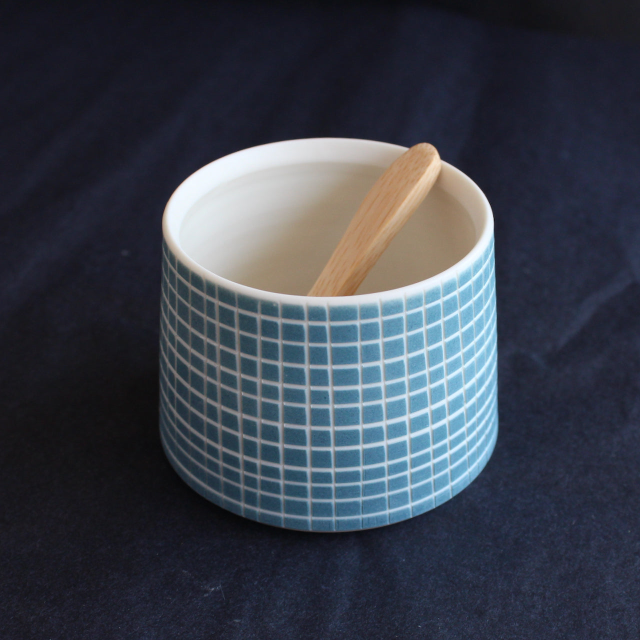 a porcelain condiment bowl by Kathryn Sherriff of By the Line Pottery decorated with a blue cross hatch glaze