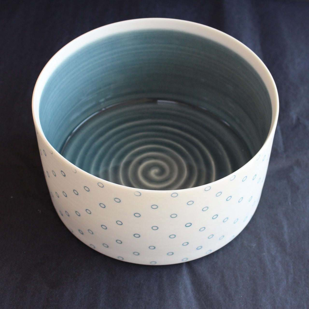 deep porcelain serving dish by Kathryn Sherriff of By the Line Pottery it has a blue glazed interior and is decorated on the exterior with small blue circles