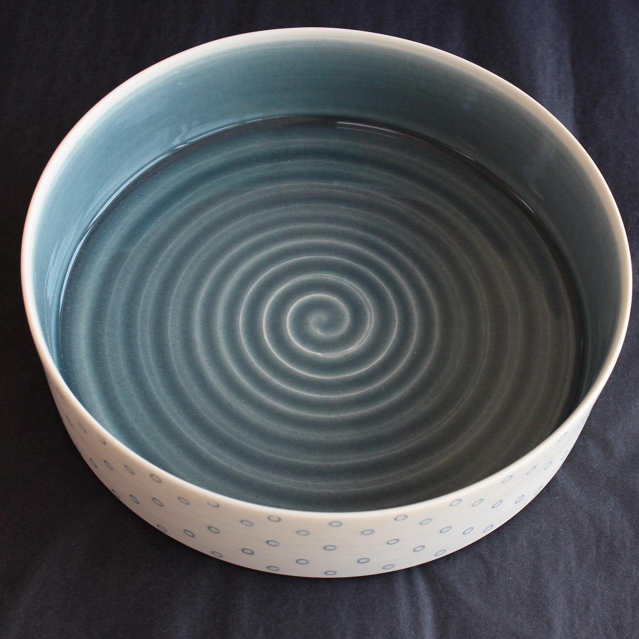 porcelain serving dish by Kathryn Sherriff of By the Line Pottery with a blue interior and a blue circle design on the exterior