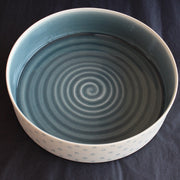 porcelain serving dish by Kathryn Sherriff of By the Line Pottery with a blue interior and a blue circle design on the exterior