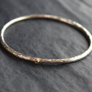 narrow textured silver bangle with small gold dot by Cornwall jewellery designer Lucy Spink