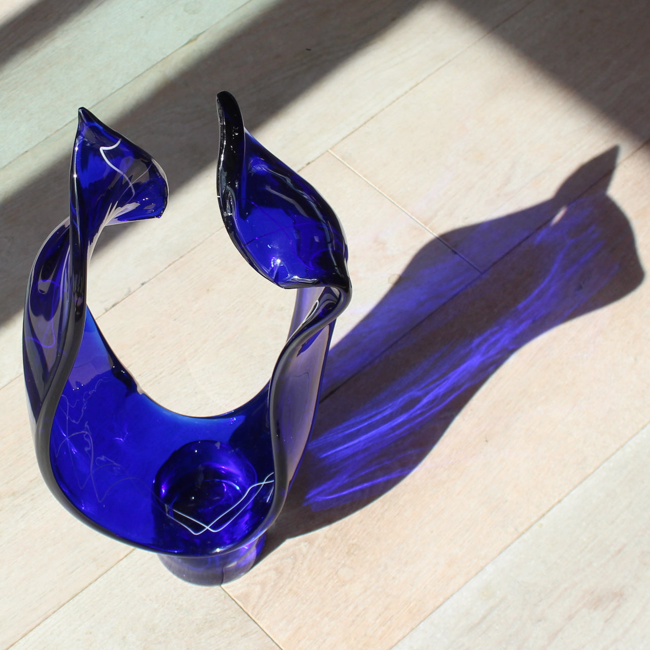 tall curved blue glass sculpture with white detail by UK glass artist Benjamin Lintell