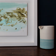 close up detail of a pale blue, white and brown abstract Katy Brown painting of flotsam on a sandy beach