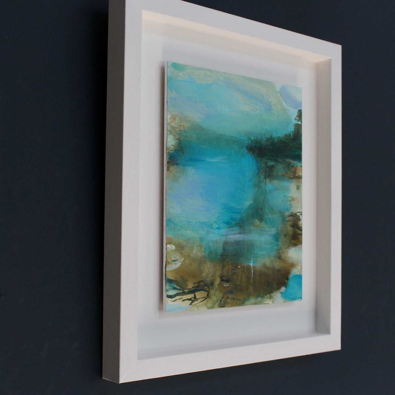 framed coastal inspired abstract painting with blue skies, and teal waters
