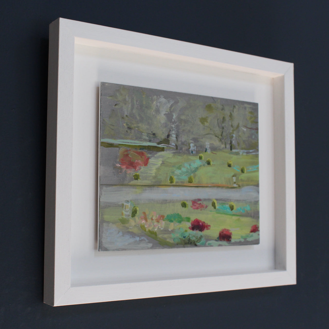 framed painting of Mount Edgcumbe Park with turquoise blue, green grass and prink flowers