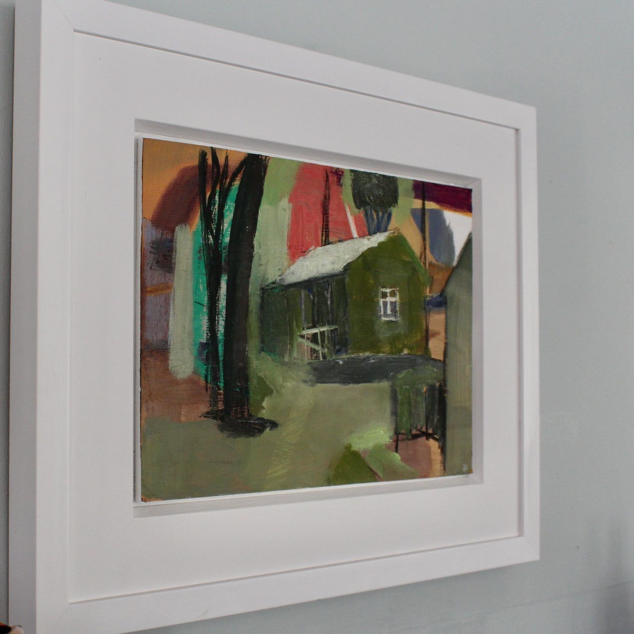 a framed oil painting by Cornwall artist Heath Hearn of a green shed with a white roof in the clearing of some trees.