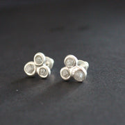 pair of silver and diamond stud earrings by Carin Lindberg each earring is made of three raw diamonds set in silver in a  triangular  formation