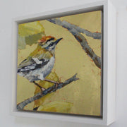 a framed Jill Hudson painting of Fire Crest bird on a twig with a gold leaf background