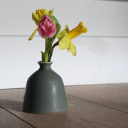 EOT ceramics bud vase in dark olive with two daffodils and a pink tulip in it