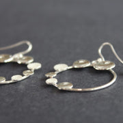 Round silver hoop earrings with small silver circles attached by Beverly Bartlett