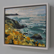 A framed painting of a coastline with yellow flowers, called Wild Yellows it is by UK artist Jill Hudson