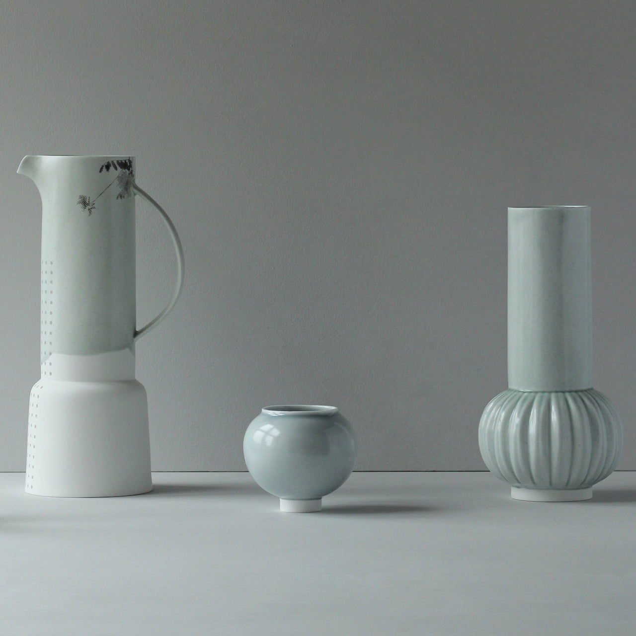 Tall pale green and white ceramic vase with handle, small pale green round bowl and tall pale green vase with round bottom and straight top