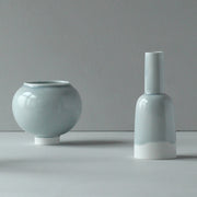 Small round pale blue round bowl with a  kiln shaped pale blue bottle with a white bottom