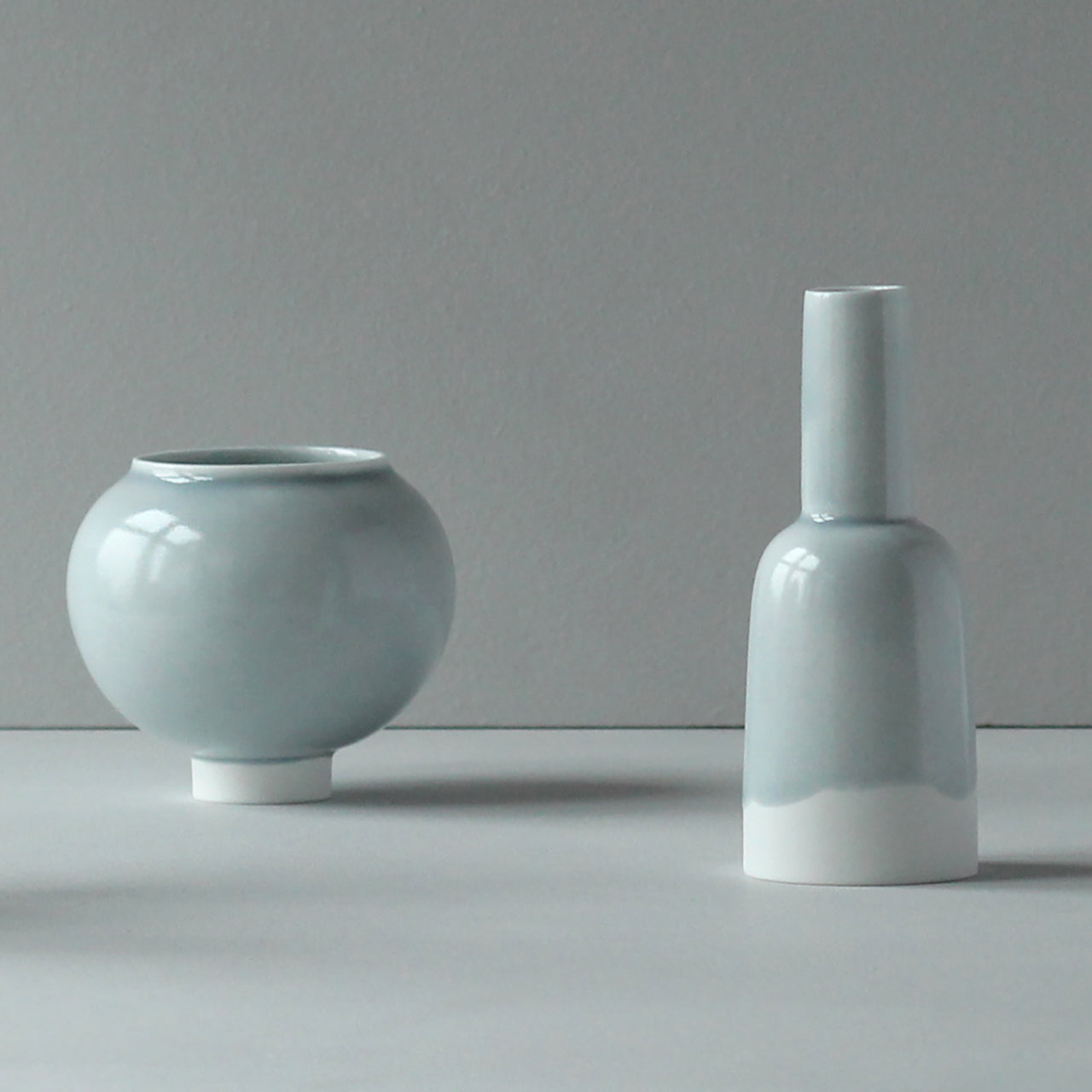 Small round pale blue round bowl with a  kiln shaped pale blue bottle with a white bottom