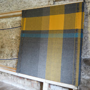 Rhian Wyman woollen throw in grey, ochre and blue on a loom
