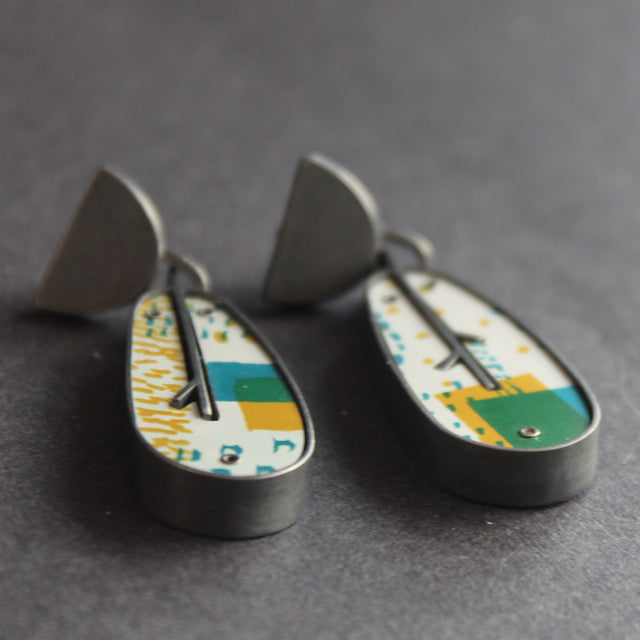 A pair of leaf shaped earrings in silver and printed aluminium in yellow and green  by Lindsey Mann