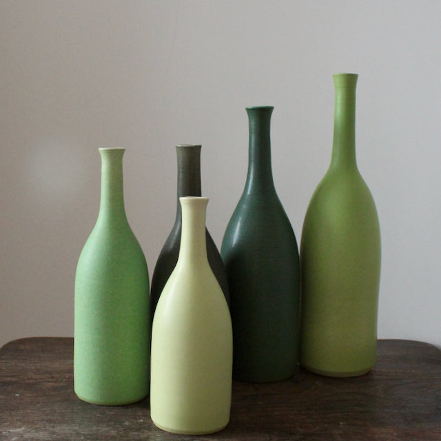 five green ceramic bottles by UK ceramicist Lucy Burley