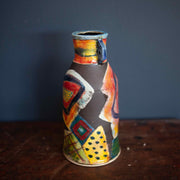 A Ceramic vase in reds, greens and blues by John Pollex