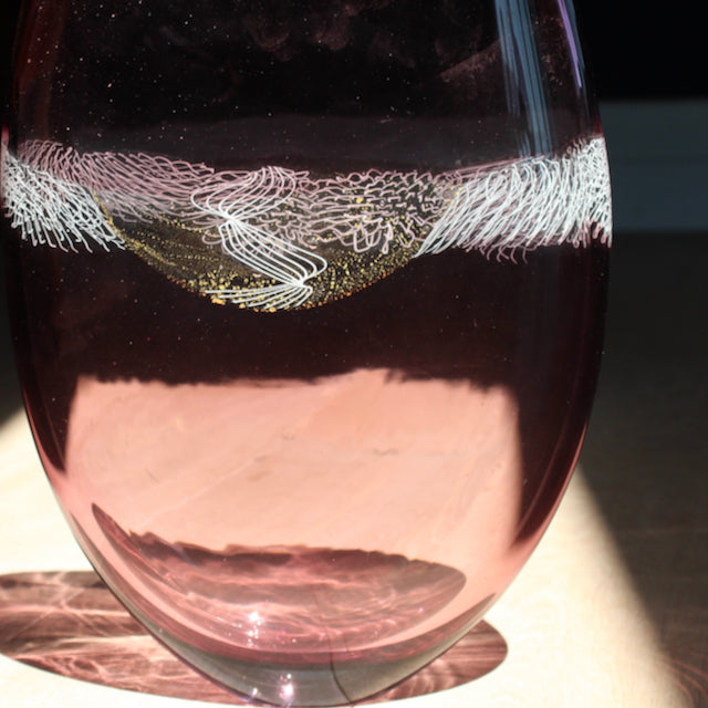 close up detail of a purple glass vessel with centre detail by Benjamin Lintell .