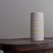 white ceramic vase with pale yellow stripes
