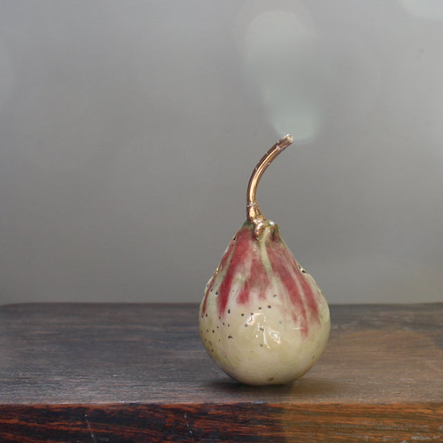 cream and pink ceramic pear with glaze details and a gold stalk by Cornwall ceramicist Remon Jephcott