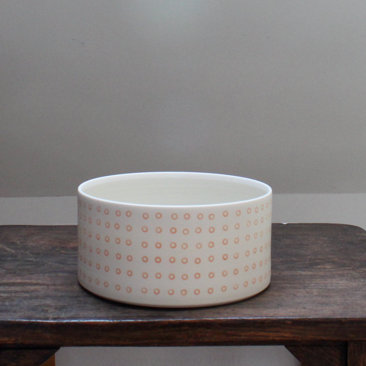 a porcelain dish decorated with small orange circles