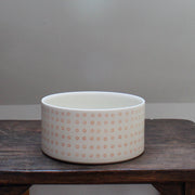 a porcelain dish decorated with small orange circles
