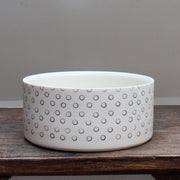 dish decorated with dark blue small circles sitting on a wooden table