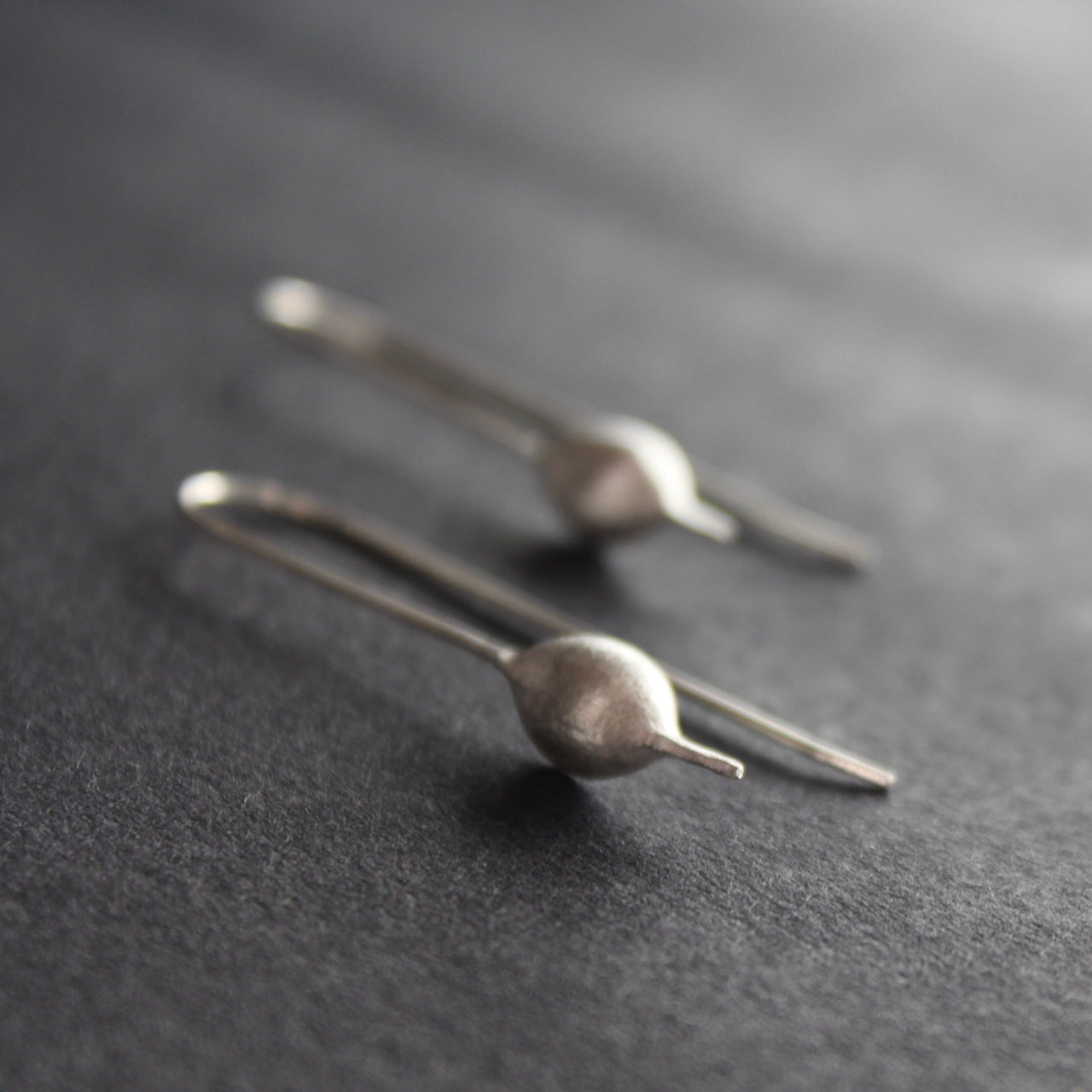 Silver drop earrings shaped like seedpods