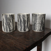 trio of small ceramic beakers by UK ceramicist Heidi Harrington with a black and white photo image of tree bark on the the exterior and cream glazed interior