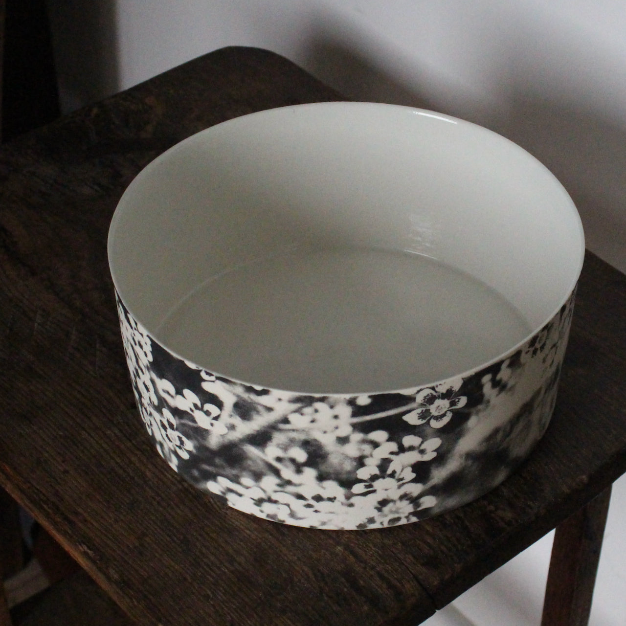 a Heidi Harrington ceramic bowl with black and white pansy design on the exterior and a cream glazed interior.