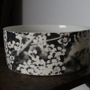 close up detail of a Heidi Harrington ceramic bowl with black and white pansy design on the exterior and a cream glazed interior