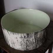 a round ceramic bowl with a green interior glaze and a black and white tree bark effect on exterior by UK ceramicist Heidi Harrington