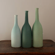 three ceramic bottles in different shades of turquoise and incremental sizes by UK ceramicist Lucy Burley