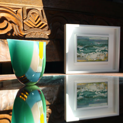 Ruth Shelley glass vessel on a mirror next to a small Cornish seascape painting by Jill Hudson