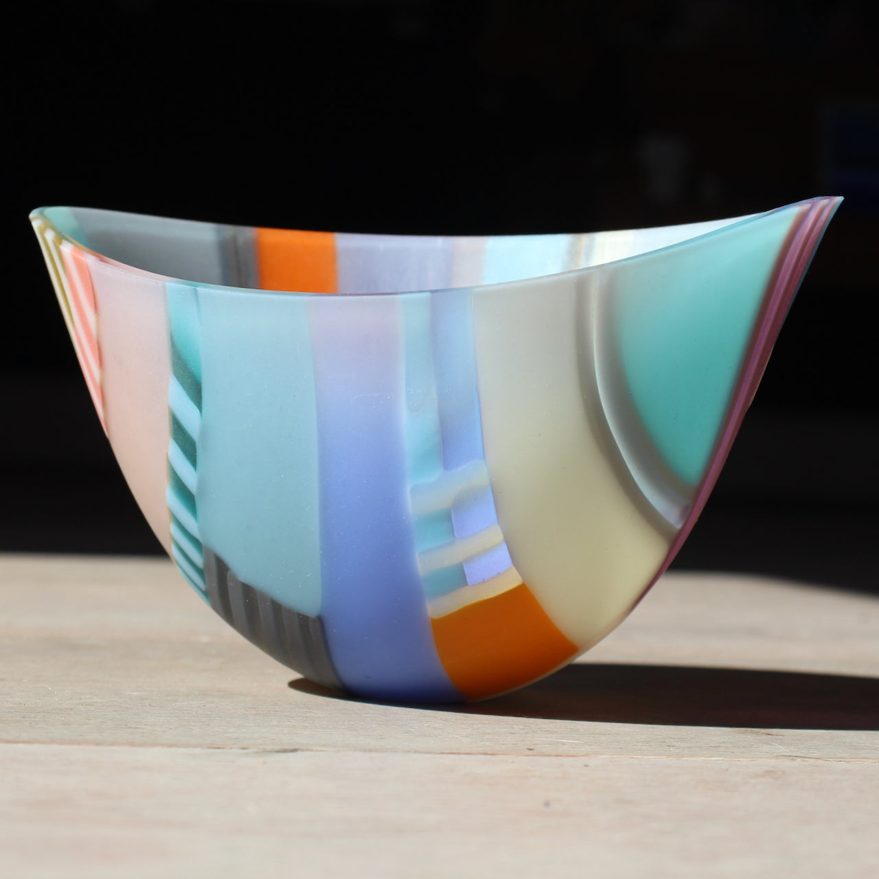 Beautiful oval shaped bowl in tones of blue, orange, yellow and grey by glass artist Ruth Shelley