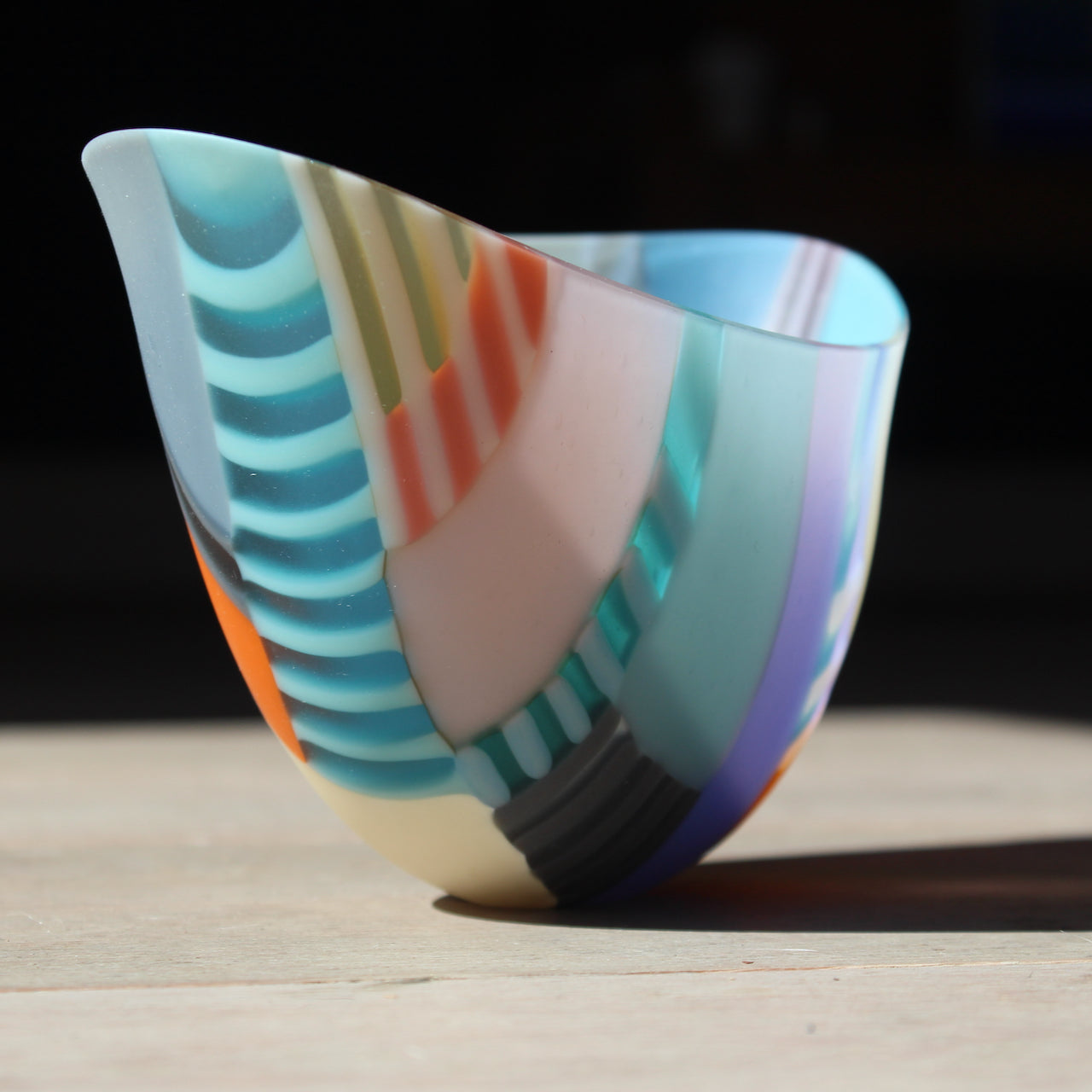 Beautiful oval shaped bowl by glass artist Ruth Shelley in tones of blue, orange, yellow and grey.
