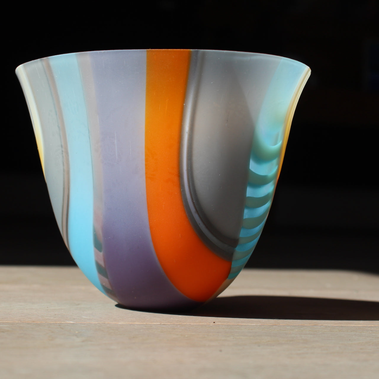 Round shaped bowl in vibrant tones of blue, orange, grey, pink by glass artist Ruth Shelley.