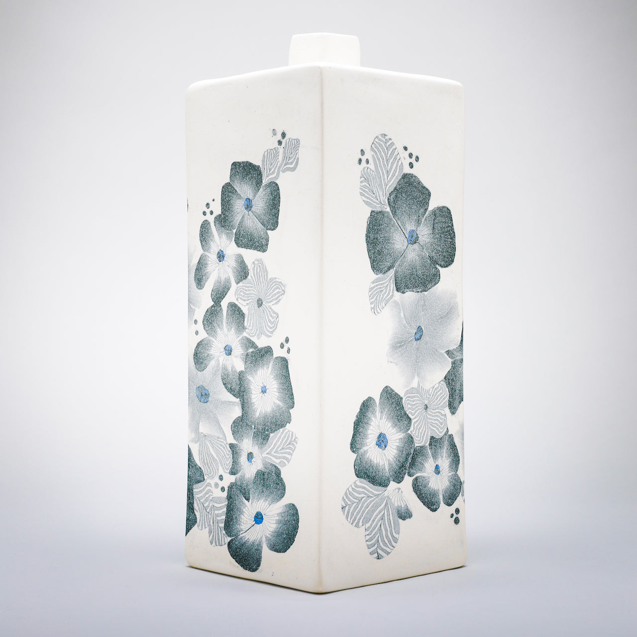 Square bottle, white background with grey floral pattern by Judy McKenzie