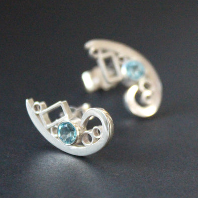Silver curved design stud earrings set with topaz by artist Beverly Bartlett