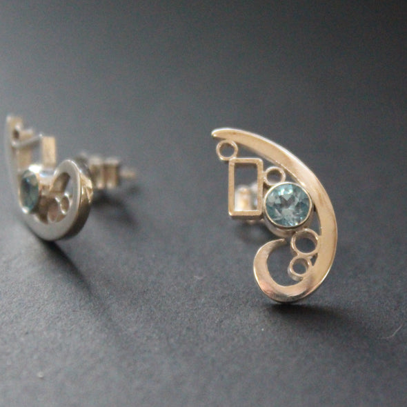 Silver curved design stud earrings set with topaz by artist Beverly Bartlett.