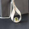 Drop curved hollow pendant set with peridot by artist Beverly Bartlett