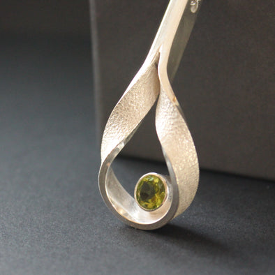 Drop curved hollow pendant set with peridot by UK artist Beverly Bartlett