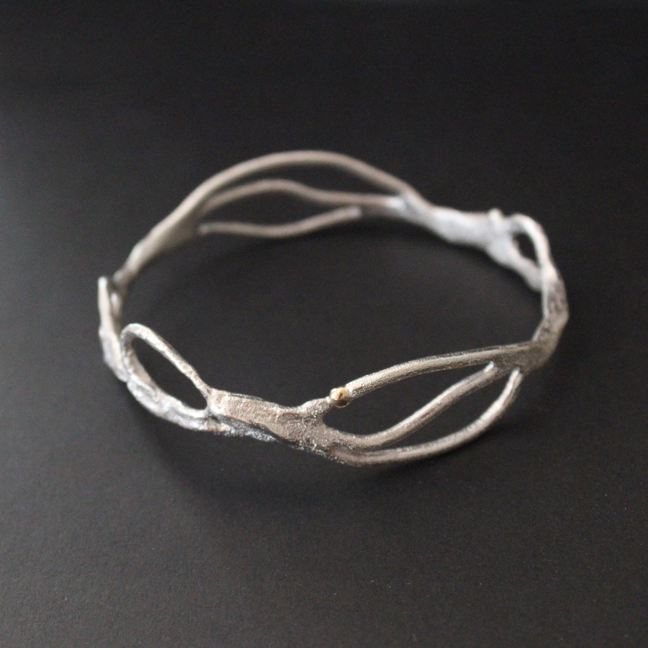 Organically hand sculpted silver Sea Siren bangle with delicate hand created surface detail and gold accent by artist Claire Stockings-Baker