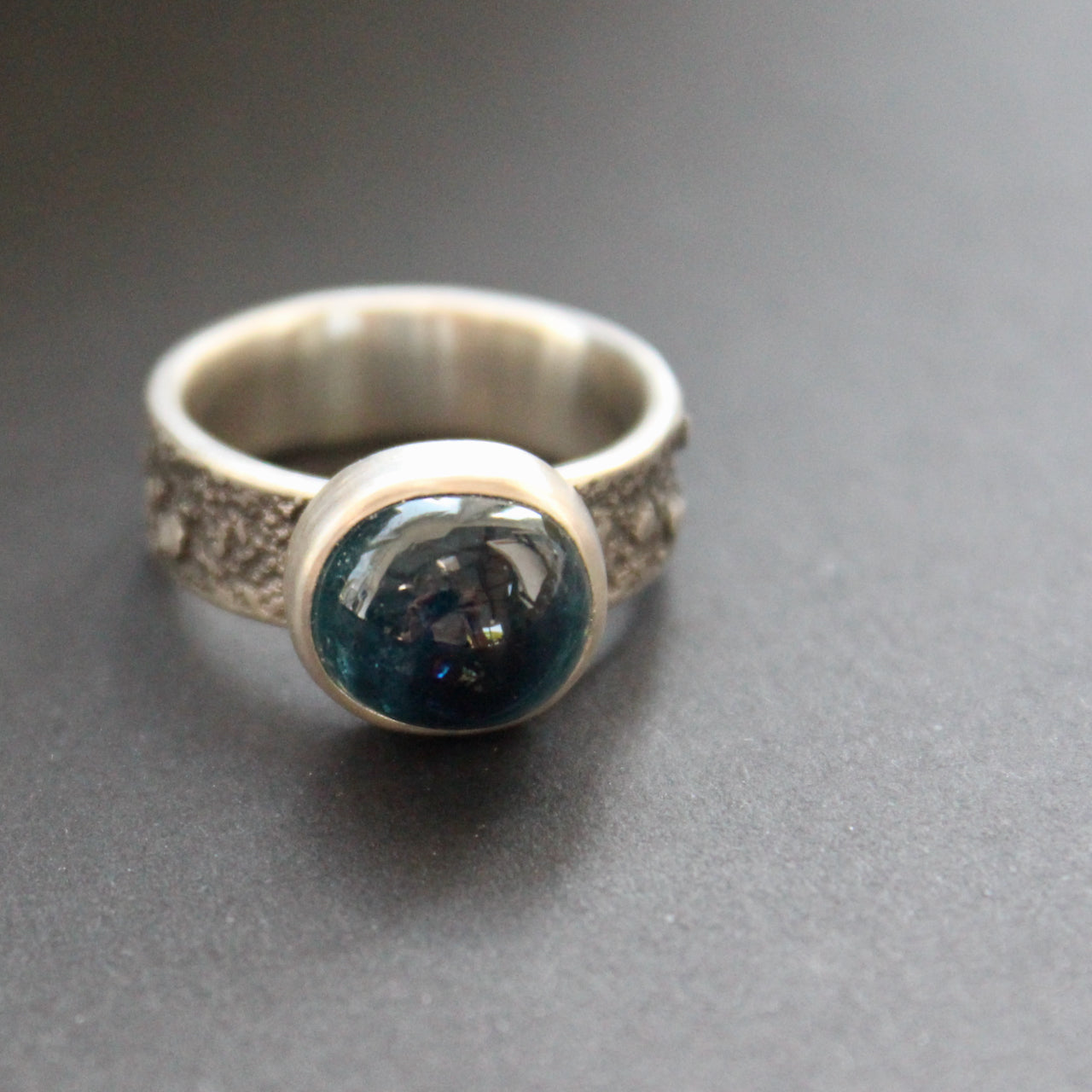 textured silver ring with a round dark blue stone in a brushed silver setting by UK jeweller Carin Lindberg