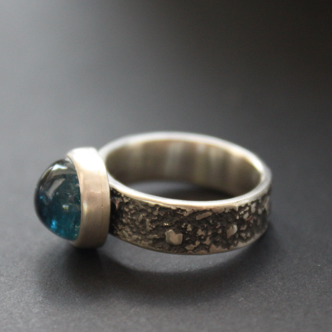 a textured silver ring with a round dark blue stone in a brushed silver setting by UK jeweller Carin Lindberg.