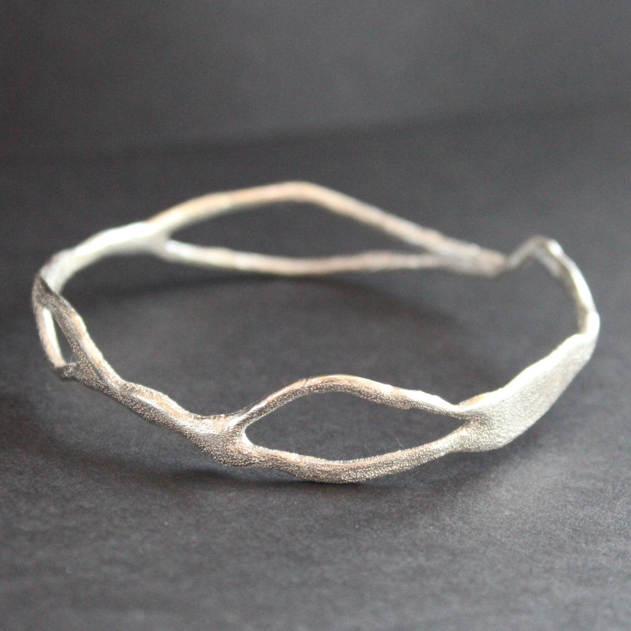 Organically shaped silver bangle by UK artist Claire Stockings Baker.