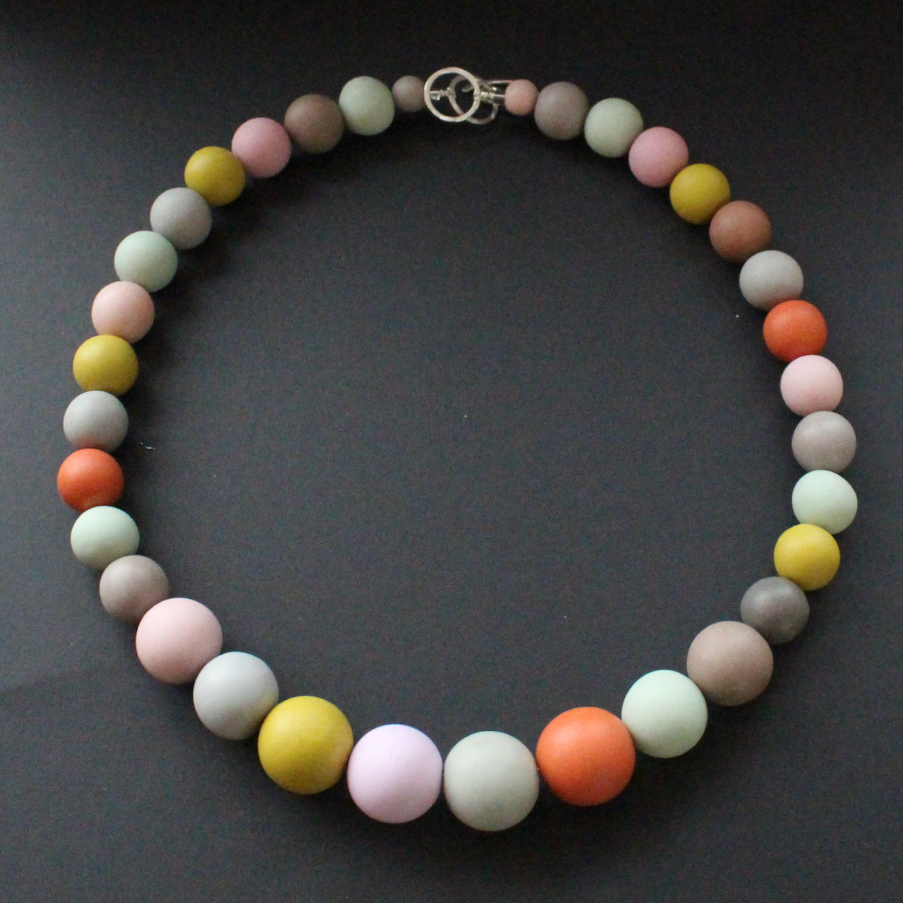 Graduated size round beaded necklace in muted earth tones by UK artist Clare Lloyd.